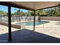 Covered back patio overlooking a fenced pool area with mature trees and landscaping at 5514 E Pershing Ave, Scottsdale, AZ 85254