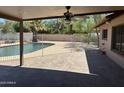 Covered back patio with a view of the fenced pool area and lush backyard landscaping at 5514 E Pershing Ave, Scottsdale, AZ 85254