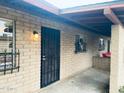 Home exterior featuring a secure iron gate, brick accents, and a cozy, covered patio area at 6729 N 16Th St # 21, Phoenix, AZ 85016