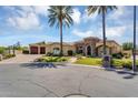 Beautiful home exterior with lush landscaping, palm trees, and brick driveway on a sunny day at 8325 W Cantera Ave, Peoria, AZ 85383