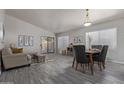 Open concept living area with wood-look floors, modern furniture, and natural light at 8569 W Voltaire Ave, Peoria, AZ 85381