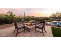 Outdoor firepit area with comfortable seating, desert views, and lush landscaping near pool at 9301 E Via Montoya --, Scottsdale, AZ 85255