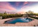 Backyard oasis featuring a sparkling pool, travertine patio, and desert landscaping with mountain views at 9301 E Via Montoya --, Scottsdale, AZ 85255