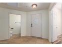 Bright foyer featuring tile flooring, a front door with glass detail, and a half bathroom at 9455 E Raintree Dr # 1025, Scottsdale, AZ 85260