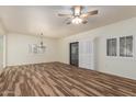 Spacious living room with wood-look flooring, plantation shutters, and a ceiling fan at 9455 E Raintree Dr # 1025, Scottsdale, AZ 85260