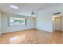 Bright living room featuring parquet floors, a ceiling fan, large windows, and neutral walls at 13631 N 103Rd Ave, Sun City, AZ 85351