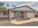 Inviting brick home with a covered front porch and desert landscaping, perfect for relaxing at 15841 N 23Rd Pl, Phoenix, AZ 85022
