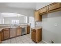 A bright kitchen featuring wood cabinetry, stainless steel appliances, and tiled floors at 16077 W Larkspur Dr, Goodyear, AZ 85338