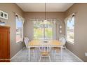 Bright dining room with a wooden table, four chairs, and abundant natural light from the window at 16527 W Blackhawk Ct, Surprise, AZ 85374
