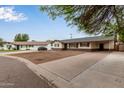 Street view of a single-story home featuring a convenient carport and a long driveway at 2022 E Mulberry Dr, Phoenix, AZ 85016