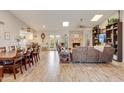 Spacious open-concept living area featuring wood-look tile flooring, a stone fireplace, and ample seating at 2328 W Nopal Ave, Mesa, AZ 85202