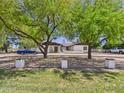 An inviting home surrounded by mature trees with a long driveway and well-maintained lawn at 2331 E Melrose St, Gilbert, AZ 85297