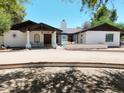 Charming white home featuring a covered entry, decorative accents, and a well-manicured front yard at 2331 E Melrose St, Gilbert, AZ 85297