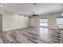 Spacious living room with wood-look floors and large sliding glass doors at 23408 W Barwick Dr, Wittmann, AZ 85361