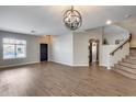 Bright living room features wood flooring, an elegant light fixture, and staircase to the left at 23420 N 121St Ave, Sun City, AZ 85373