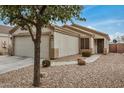 Beige single-story home featuring desert landscaping, a two-car garage, and a welcoming entrance at 24009 W Antelope Trl, Buckeye, AZ 85326