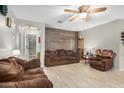 Bright living room with tile floors, neutral walls, wood accent wall and a ceiling fan at 24009 W Antelope Trl, Buckeye, AZ 85326