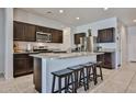 Spacious kitchen with dark wood cabinets, stainless steel appliances, and a large center island with seating at 30935 W Mulberry Dr, Buckeye, AZ 85396