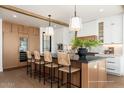 A stunning kitchen with seating for five, a modern refrigerator, wine cooler, and beautiful, warm hardwood floors at 3913 E Campbell Ave, Phoenix, AZ 85018