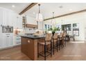Spacious kitchen with white cabinetry, stainless steel appliances, a center island with seating, and hardwood floors at 3913 E Campbell Ave, Phoenix, AZ 85018
