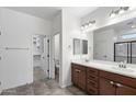 Well-lit bathroom featuring double sinks, vanity with drawers, and walk-in closet access at 5429 W Chuck Box Rd, Laveen, AZ 85339