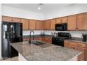 Kitchen features granite countertops, a kitchen island with a sink, and black appliances at 5429 W Chuck Box Rd, Laveen, AZ 85339