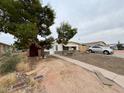 Home exterior featuring mature trees, carport, and walkway at 639 S 92Nd Pl, Mesa, AZ 85208