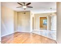 Spacious living room featuring hardwood floors, ceiling fan, and adjacent rooms with connecting doorway at 6885 E Cochise Rd # 129, Paradise Valley, AZ 85253