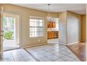Light-filled room with tile floors, hardwood accents, modern chandelier, and a view into the kitchen at 6885 E Cochise Rd # 129, Paradise Valley, AZ 85253