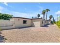 Beige home with mature landscaping and paver walkway surrounded by desert landscaping at 701 W Windsor Ave, Phoenix, AZ 85007