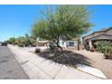 Inviting single-story home featuring desert landscaping, trees, and a well-kept lawn at 7126 W Ocotillo Rd, Glendale, AZ 85303