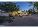Striking exterior elevation with an arched window, terracotta roof and lush desert landscaping at 7471 E Northern Ave, Scottsdale, AZ 85258