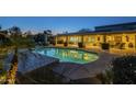 Sparkling pool with an illuminated patio and outdoor seating, perfect for evening relaxation at 7471 E Northern Ave, Scottsdale, AZ 85258