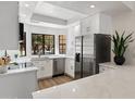 Bright kitchen featuring white cabinets, quartz countertops, stainless steel appliances and a bay window at 7760 E Pepper Tree Ln, Scottsdale, AZ 85250