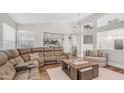 Comfortable living room featuring an oversized sectional, hardwood floors, and an open floor plan at 7931 W Harmony Ln, Peoria, AZ 85382