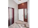 Entryway featuring a white door, tile flooring, and burgundy accent wall at 8341 W Gross Ave, Tolleson, AZ 85353
