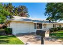Well-maintained single-story home with a garage, tidy lawn, and welcoming curb appeal at 9863 W Country Club Ct, Sun City, AZ 85373