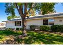 Attractive single-story home with tidy landscaping and mature shade trees on a sunny day at 9863 W Country Club Ct, Sun City, AZ 85373