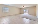 Bright, open living space with tile flooring, carpet, a ceiling fan, and sliding glass doors at 10837 W Bloch Rd, Tolleson, AZ 85353