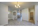 Bright living room with wood-look floors, chandelier, and access to other rooms in the home at 1624 N 77Th Gln, Phoenix, AZ 85035