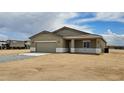 Single story home with a two-car garage and neutral-toned exterior in desert community at 20411 W Mountain Sage W Dr, Buckeye, AZ 85326