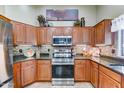 Well-equipped kitchen featuring wood cabinetry, stainless steel appliances, and granite countertops at 2101 S Meridian Rd # 250, Apache Junction, AZ 85120