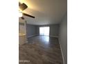 A spacious living room featuring wood floors and a sliding glass door with access to the outside at 2121 W Royal Palm Rd # 1014, Phoenix, AZ 85021