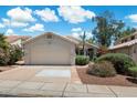 Charming single-story home with a two-car garage, mature landscaping, and a tile roof, set against a beautiful blue sky at 21675 N 61St Ave, Glendale, AZ 85308
