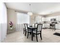 Bright dining room with modern chandelier, seating for six, and seamless flow to the kitchen at 2543 N 73Rd Dr, Phoenix, AZ 85035