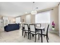 Bright dining room with modern chandelier, seating for six, and seamless flow to the living area at 2543 N 73Rd Dr, Phoenix, AZ 85035