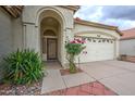 Inviting front entry with security door, desert landscaping, and flowering shrub; the front door has an arched entryway at 3631 E Long Lake Rd, Phoenix, AZ 85048