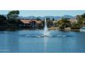 Scenic lake view featuring a water fountain and homes with red tile roofs, against a backdrop of distant mountains at 3631 E Long Lake Rd, Phoenix, AZ 85048