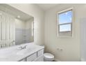 Clean bathroom featuring a white vanity, large mirror, and walk in shower with neutral paint at 37549 W San Clemente St, Maricopa, AZ 85138