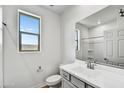 Bright bathroom featuring a white vanity, framed mirror and shower with a window providing natural light at 37551 W Patterson St, Maricopa, AZ 85138